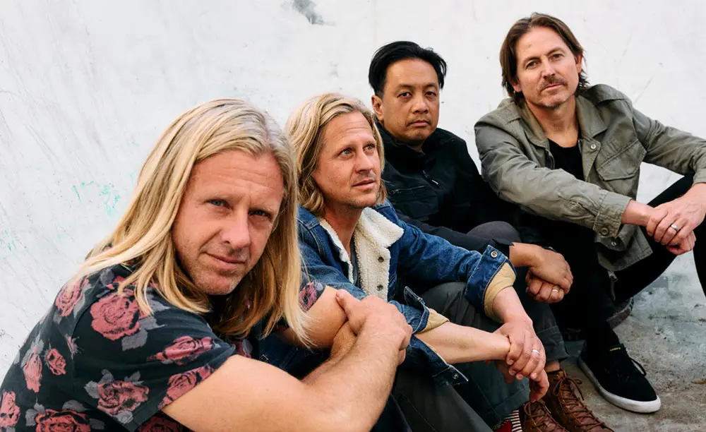 Band members sitting in an empty pool.
